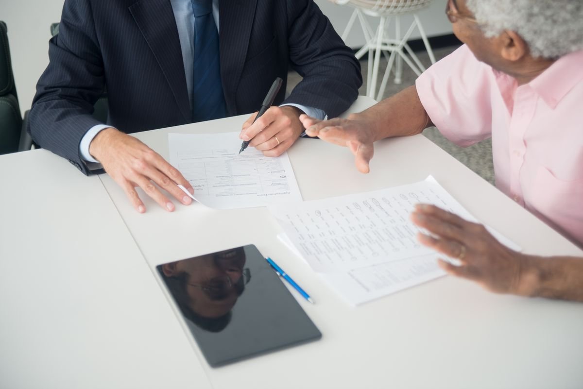 Two people going over Medicaid behavioral health benefit documents together at an office table